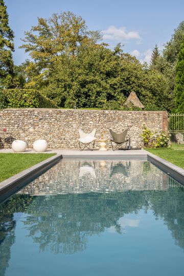 Avec son air de cours d'eau, la piscine donne un aspect de rivière, un côté naturel à ce jardin normand.